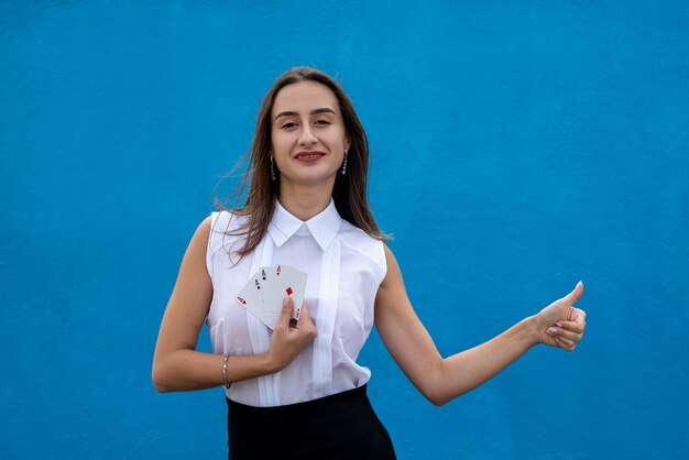 Female player holding poker cards isolated on blue background. Game