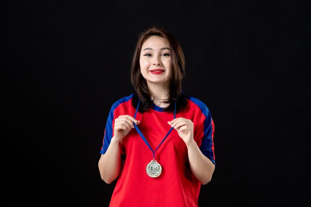 Female player with gold medal on black