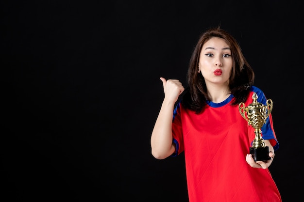 Female player with golden cup on a black