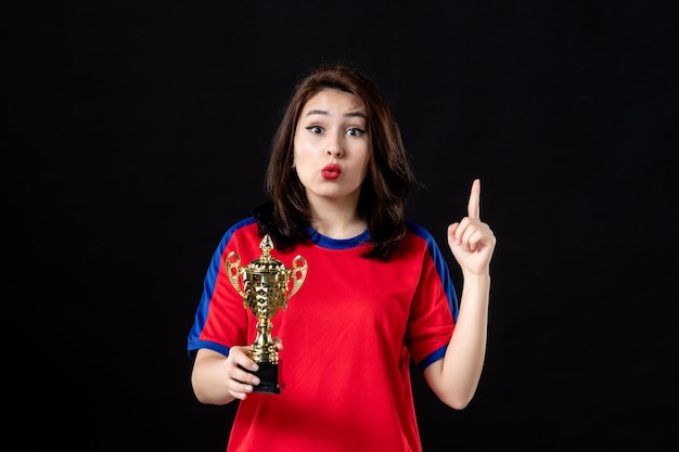 Female player with golden cup on black