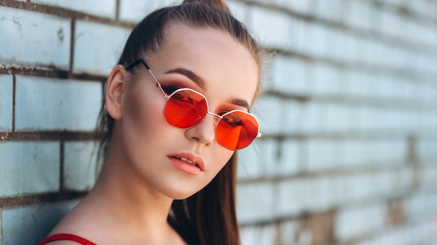 Female portrait in red sunglasses outdoors