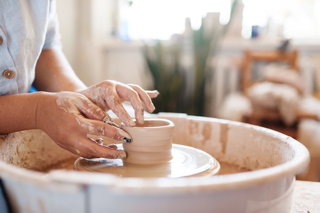 写真 ろくろで鍋を作る女性の陶芸家。ボウルを成形する女性。