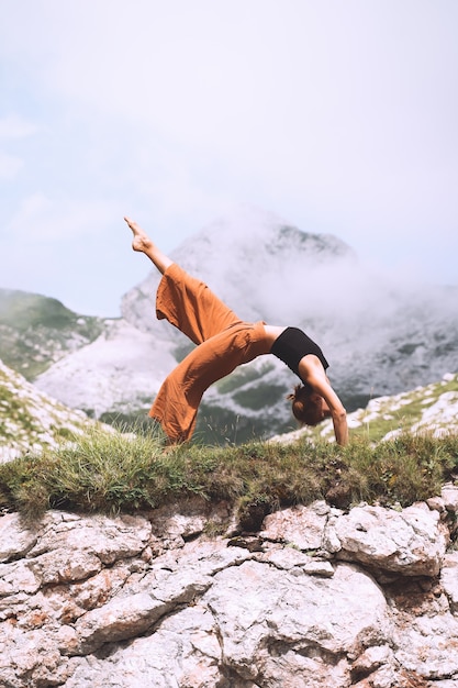 Female practicing yoga on nature Young woman doing yoga in mountains