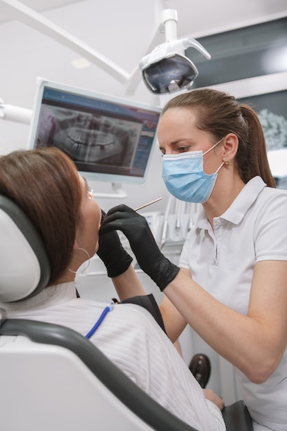 Foto dentista professionista femminile che lavora alla sua clinica