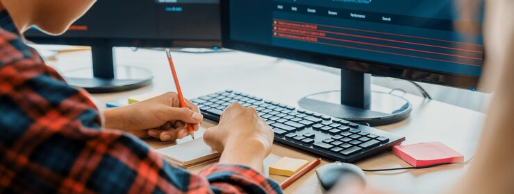 Photo female programer taking a note while young skilled web developer present program while computer displayed program code at modern office company java script web design concept burgeoning