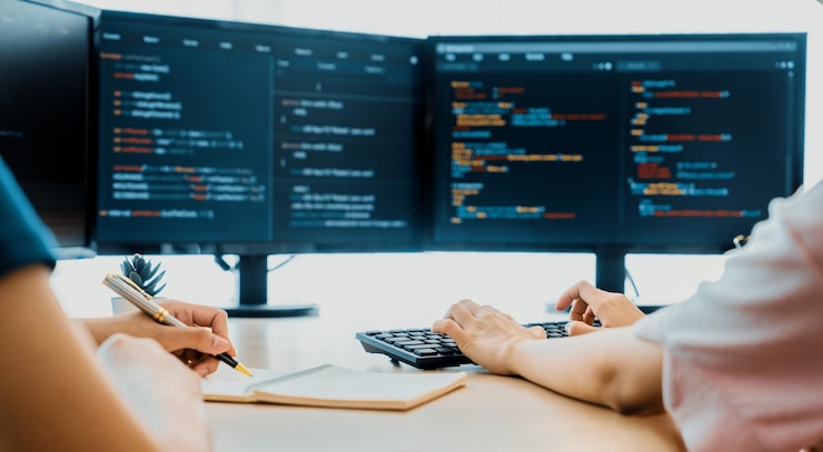Photo female programer taking a note while young skilled web developer present program while computer displayed program code at modern office company java script web design concept burgeoning