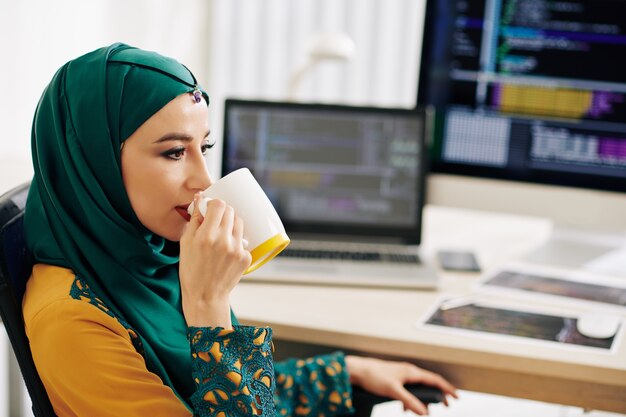 Female programmer drinking coffee