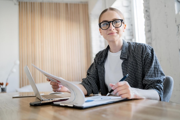 A female programmer works uses a laptop makes a report to a programming company