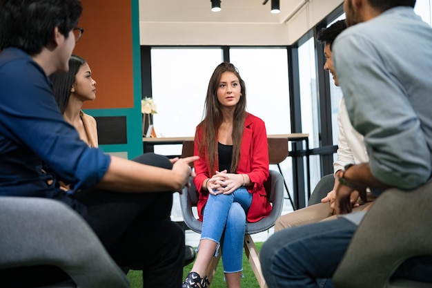 Photo female psychiatrist discussing with people in office