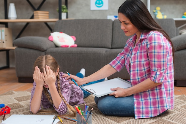 Foto psicologa femminile che conforta la bambina piangente