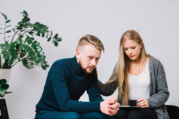 Foto psicologo femminile che conforta paziente maschio depresso e preoccupato