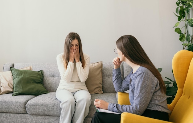 A female psychologist provides psychological assistance to a distressed female patient. Domestic violence. Depression