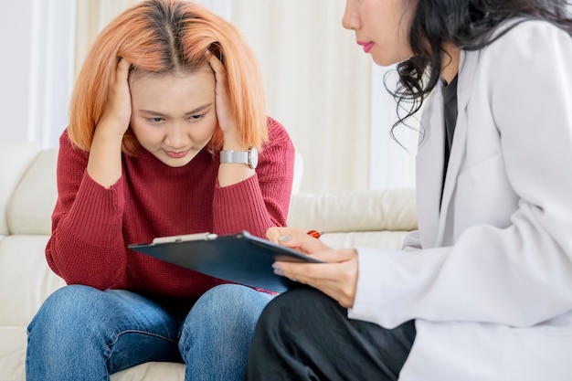 Foto psicologa femminile che prende appunti sugli appunti con una paziente adolescente sconvolta in una clinica concetto di salute mentale
