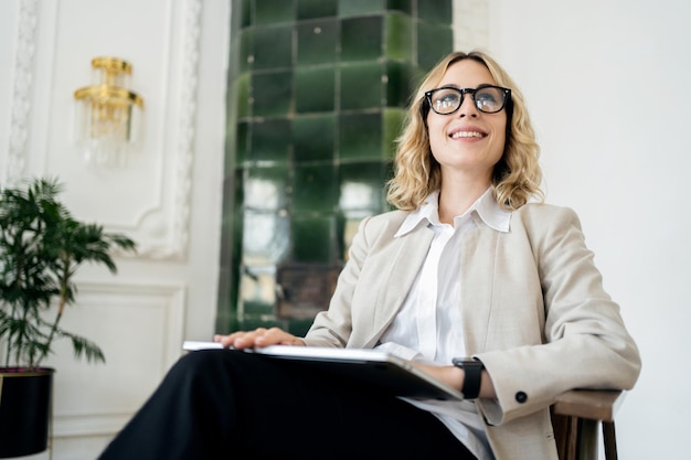 A female psychologist works in an office online report uses a laptop