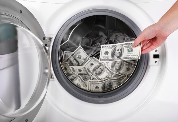 Photo female putting money into washing machine closeup