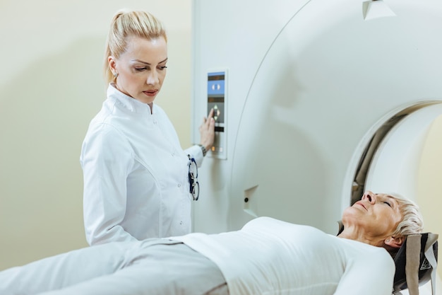 Female radiologist and mature patient during MRI scanning procedure in the hospital