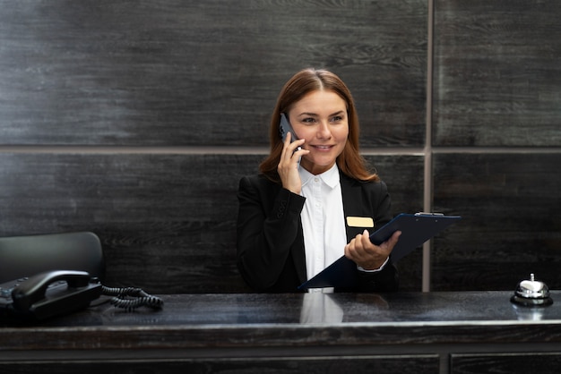 Foto addetta alla reception femminile in abito elegante durante l'orario di lavoro