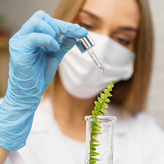 Foto ricercatore femminile con mascherina medica in laboratorio