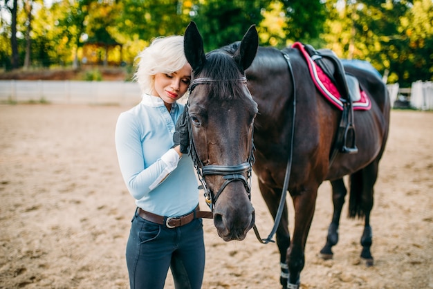 女性ライダーが馬を抱きしめ、乗馬