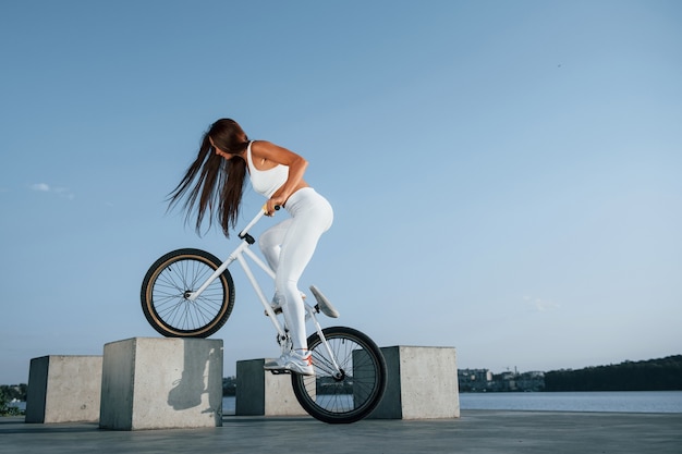 Photo female rider is on the bike at daytime near the lake