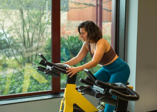 Photo female riding a bike in a gym