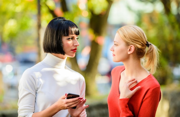 Female rivalry Friendship problems rivalry and jealousy Pretty girls friends sisters Eye contact Women looking at each other with attention Rivalry and leadership Blonde brunette competitors