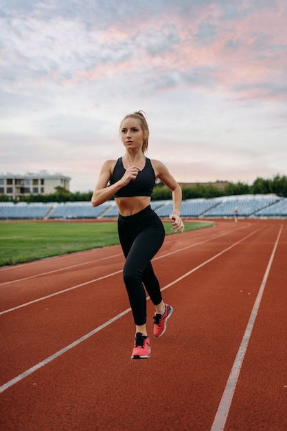 Female runner jogging, training on stadium
