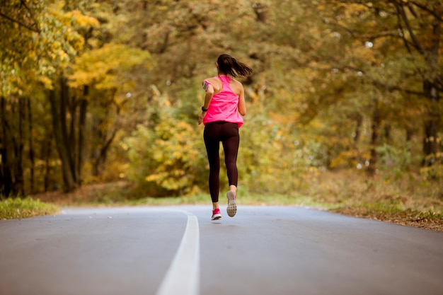 Female runner running during outdoor workout in the park.