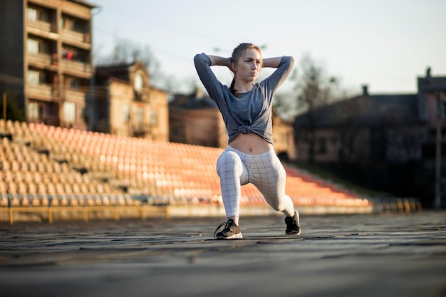 Female runner stretching legs on running track