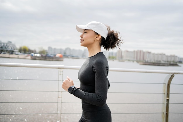 A female runner uses a fitness watch for training the trainer is dressed in a tracksuit