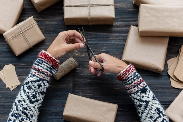 写真 クリスマスのギフトボックスを包む女性の手