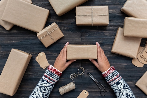 Foto mani femminili che avvolgono il contenitore di regalo di natale