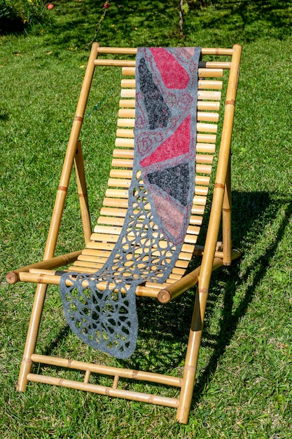 Female scarf of felted wool on bamboo lounger on lawn