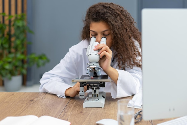 Foto la scienziata in cappotto di medicina lavora in un laboratorio scientifico