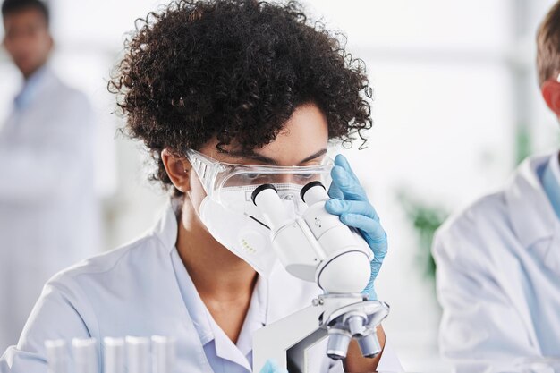 Female scientist in protective clothing works in a scientific laboratory