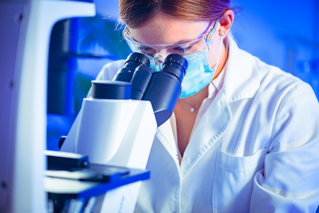 Photo female scientist researching samples in laboratory