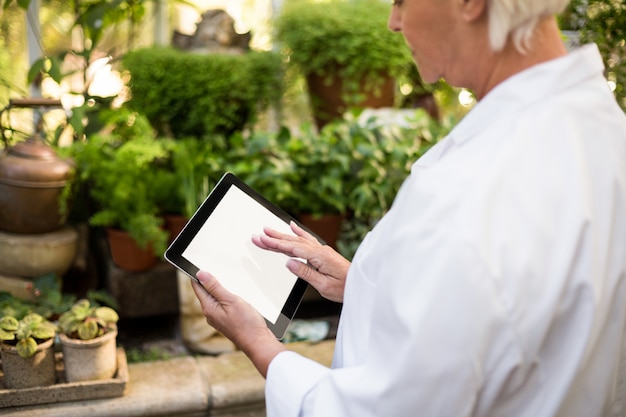 female scientist using tablet computer at greenhouse