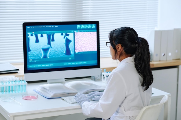 Female scientist or virologist with dark long hair studying new strain of virus