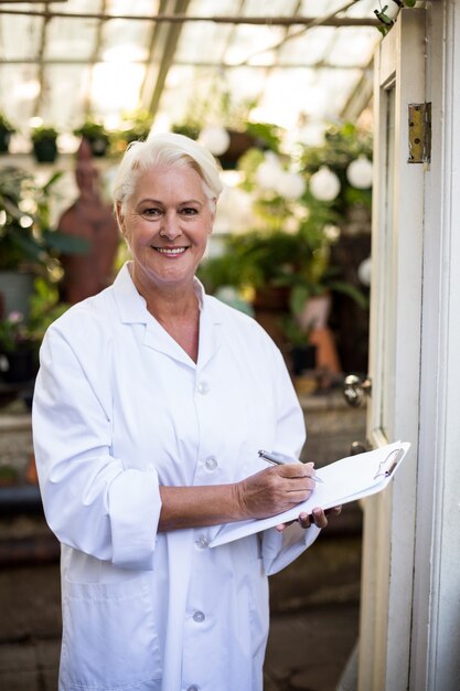 Female scientist with clipboard at doorway