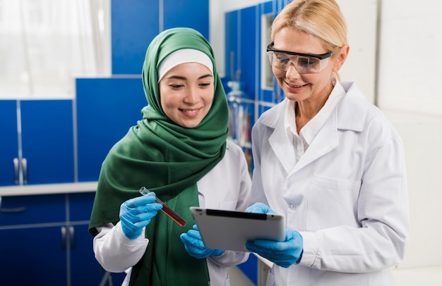 Foto scienziate in laboratorio che lavorano con tablet