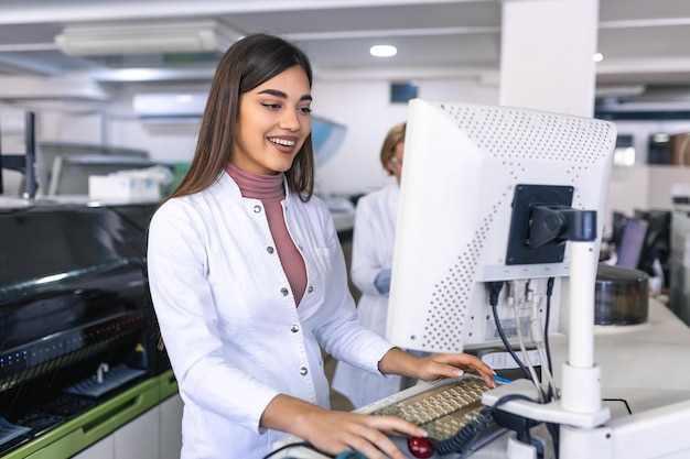 Female Scientists Programs Medical Equipment with Personal Computer Team Of Professionals Working in Pharmaceutical Research Modern Laboratory