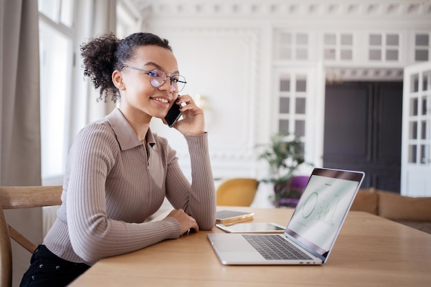 A female secretary with glasses works in an office uses a laptop reports to a finance company