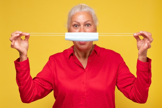 Female senior patient showing medical protective mask looking at camera rules of visiting public places