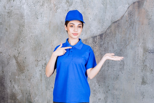 Foto agente di servizio femminile in uniforme blu che mostra il lato destro.