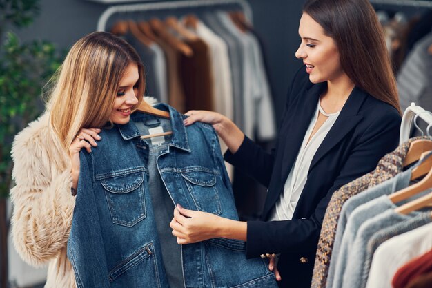 female shop assistant helping customer in boutique