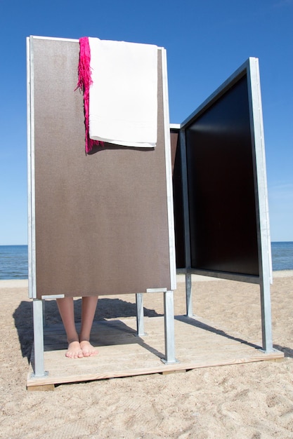 Foto gambe sottili femminili in cabina spogliatoio sulla spiaggia