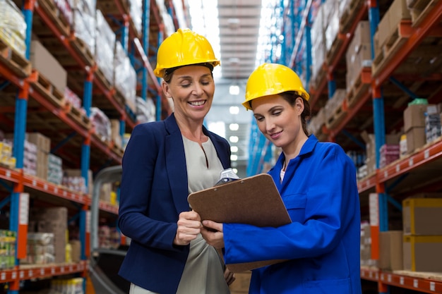 Female smiling coworkers looking at clipboard