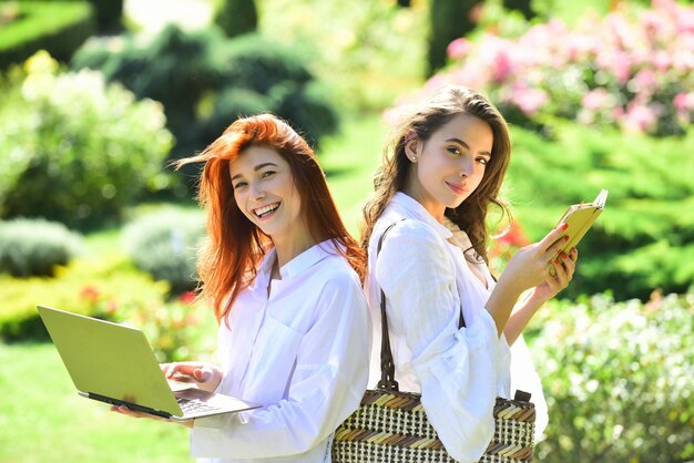 Female smiling friends students outdoors summer holidays education campus and teenage concept