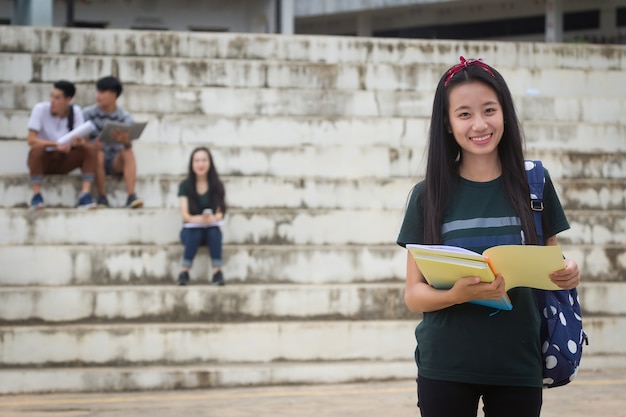 Female smiling student outdoors in the evening with friends