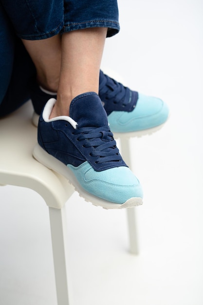 Photo female sneakers on legs blue woman's shoes on feet on chair